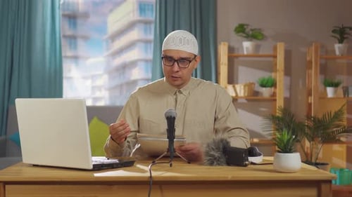 Man Recording Himself Speaking at a Desk