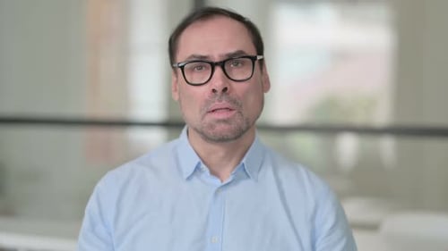 Serious Man in Glasses Looking at Camera