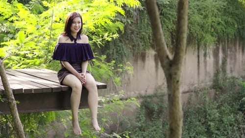 Woman Posing on Wooden Platform in Lush Nature