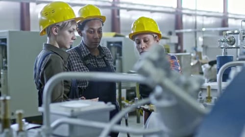 Female Engineers Inspecting Factory Equipment