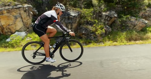 Female cyclist cycling on a countryside road