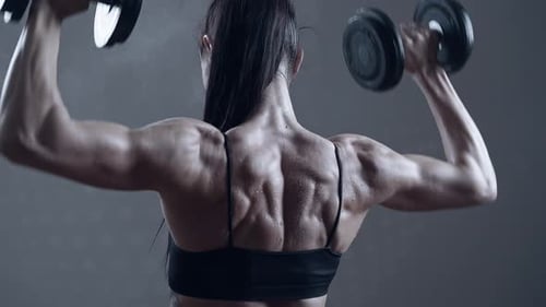 Muscular Woman Lifting Weights in Gym