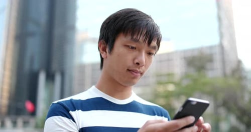 Young Adult Using Phone in City Close Up
