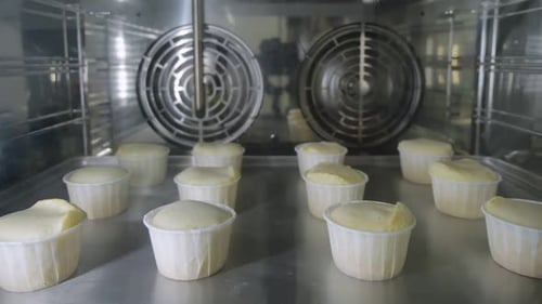 Muffins in Paper Cups Is Baking in Oven. View Through the Glass