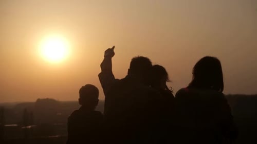 Silhouetted Family Watching Sunset Together in Nature