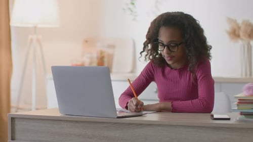 Teen Girl Studying at Desk with Laptop at Home