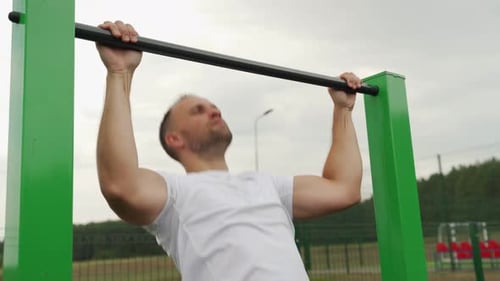 Strong Man From Behind Doing Pull Ups on Horizontal Bar