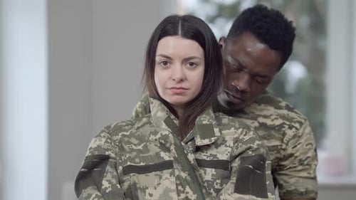 Smiling Woman Embraced by Partner in Camouflage Jacket