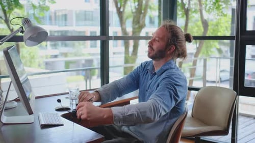 L'homme s'étire les bras après avoir terminé son travail informatique sur le lieu de travail et reste à la maison