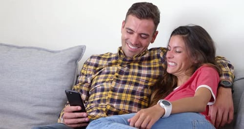 Couple Relaxing on Couch with Phone and Smartwatches