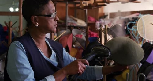 Mixed race woman working at a hat factory