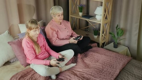 Top View of Grandmother and Granddaughter Play Video Games Together