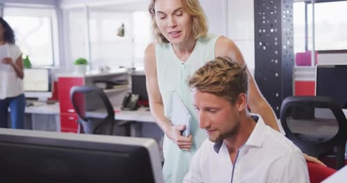 Professionelle Geschäftsfrau und Geschäftsmann diskutieren in Zeitlupe über einen Computer im Büro