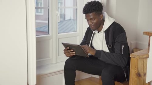 Portrait of Serious Man Sitting at Home Using Digital Tablet