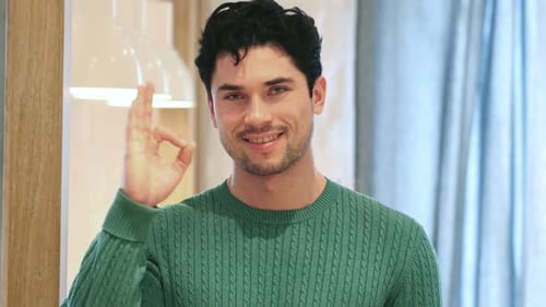 Young Man Smiles and Makes OK Gesture