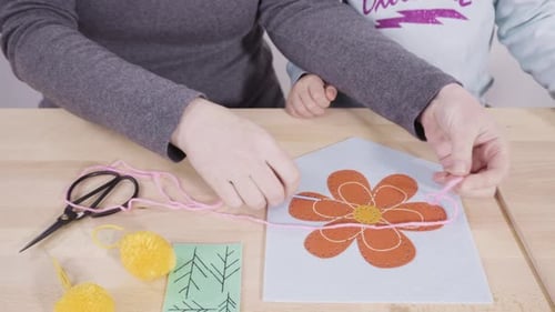 Little Girl Learning How to Sew with Her Mother at the Craft Table