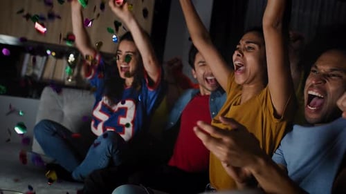 Friends Cheering Celebration on Couch at Night