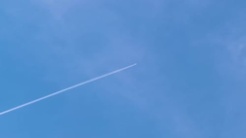 Airplane flying in blue sky with white contrail