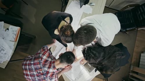 Cropped Overhead View of Skilled Architectors Discussing Different Variants for Improving Drawing