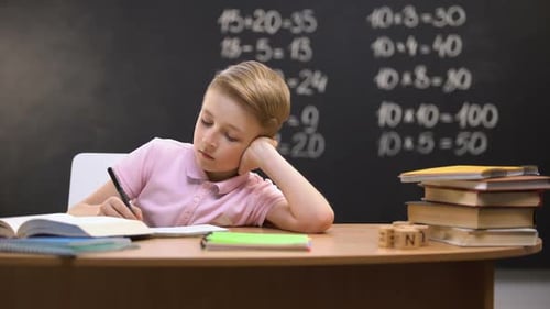 Blond-haired Boy Doing Homework in Classroom