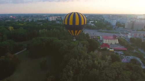 Hot Air Balloon Floating Over City Green Area in Morning, Escape from Routine