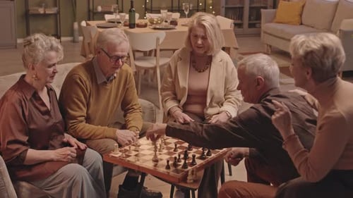 Senior Friends Enjoying a Game of Chess Indoors