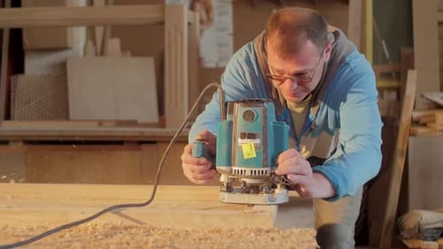 Man Uses Wood Router in Workshop