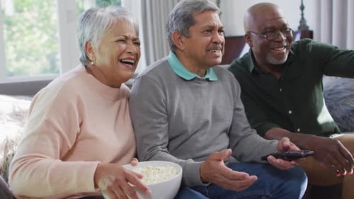 Three Silver-Haired Friends Watching TV Together