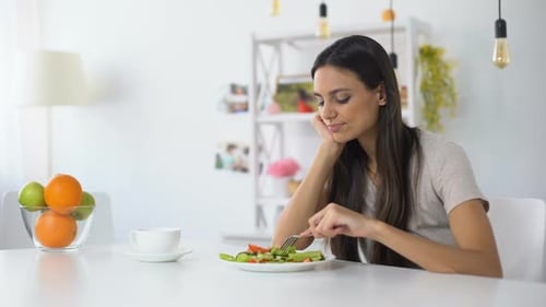 Unzufriedene Frau auf der Suche nach Salat, Gesunde kalorienarme Diät zur Gewichtsreduktion