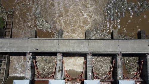 Aerial view of the water released from the concrete dam's drainage channel as the overflow