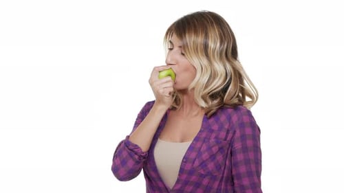 Halfturn Portrait of Happy Woman 30s Wearing Casual Clothes Eating Green Apple Tasting Enjoying
