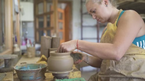 Woman Shaping Clay on Pottery Wheel in Workshop