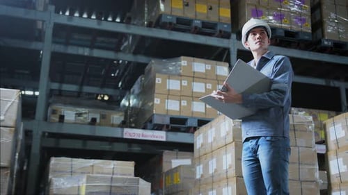 Aufnahmen des männlichen Lagerarbeiters des Ingenieurpersonals mit Schutzhelm bei der Arbeit