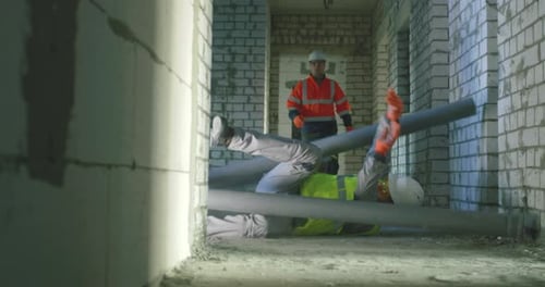 Builder Falling Under Pipes in Front of Colleague