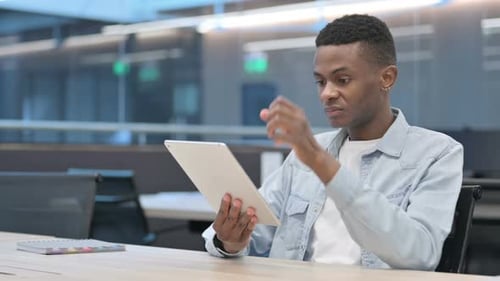 Young Adult Frustrated Using Tablet in Office