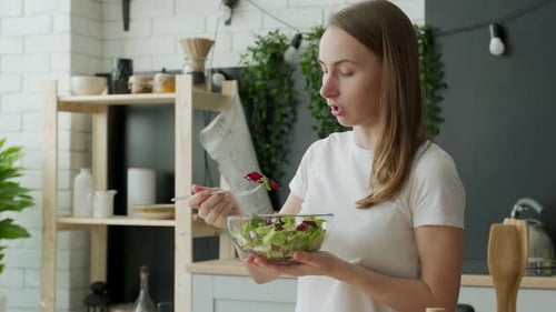 Woman Enjoys Healthy Salad in Kitchen