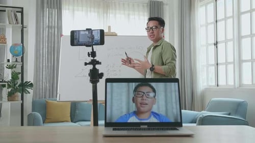 Teacher Giving an Online Lesson with Student Via Laptop