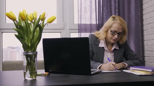 Mature Woman Working at Laptop at Home