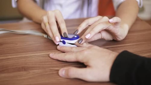 Medical Professional Using Pulse Oximeter on Patient