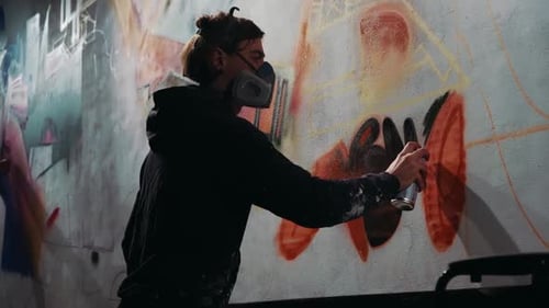 Jovem pintando grafite abstrato ao ar livre