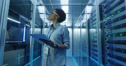 Woman Inspects Servers with Tablet in Data Center
