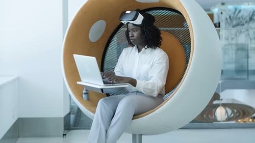 Woman Uses VR Headset and Laptop in Office
