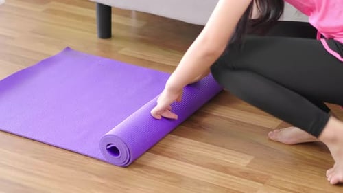Top view of B roll shot of woman roll out yoga mat for preparation