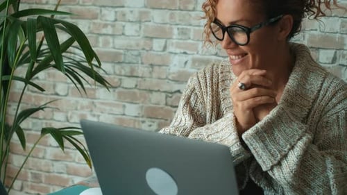 Woman with Curly Hair Smiling While Using Laptop
