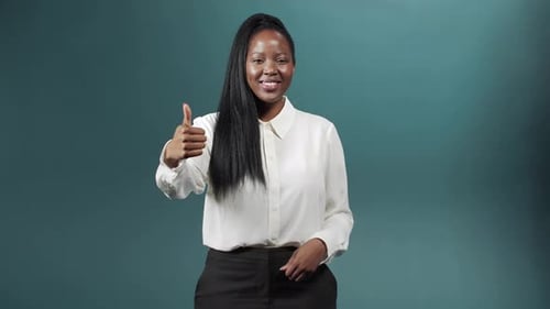 Eine lustige Afrikanerin zeigt einen Daumen hoch und lächelt