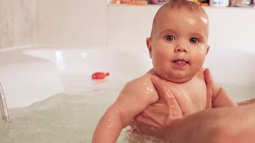 Adorable Infant Enjoying Bath Time with Parent
