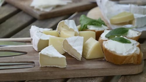 Cheese and Baguette Slices on Wooden Board