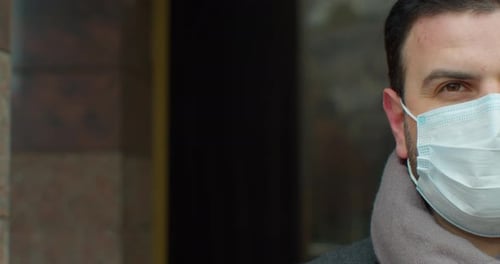 Close Up Portrait of Handsome Male in Medical Mask Standing Outdoors on Street and Looking at Camera