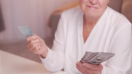 Adult Holding US Currency and a Credit Card