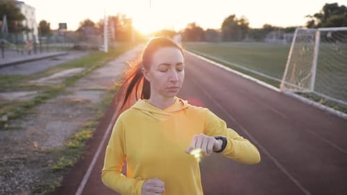 Woman Running on Track at Golden Hour